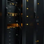 Server racks in a data center with yellow indicator lights illuminated on black equipment.