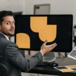 Business team reviewing brand identity design with colour swatches and logo on monitor display