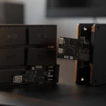 Disassembled modular computing device with exposed circuit boards and stacked components on a desk.